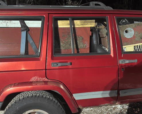 Old red Jeep Cherokee loaded with beekeeping equipment and supplies.