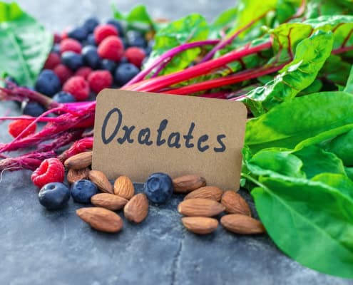 Organic blueberries, almonds, beetroot greens, and raspberries with "OxaLatcs" tag on Natural Stone surface.