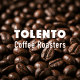 Close-up of roasted coffee beans with TOLENTO Coffee Roasters branding.